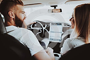 Man Is Driving A Tesla Car. Girl At Front Seat