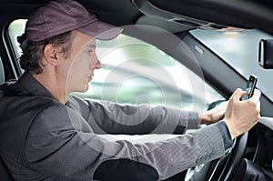 Man driving and texting someone on his cell phone