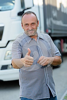 man driving truck and showing thumbs up