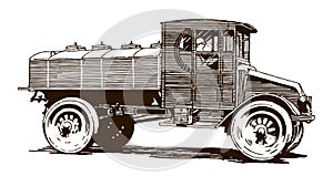 Man driving a vintage oil tank truck, in side view