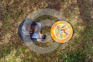 Man with a drone on the ground preparing it to fly