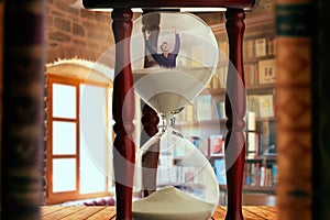 Man drowning inside an hourglass, deadline concept
