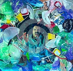 Man drowning in ocean water under plastic recipients pile, environment concept