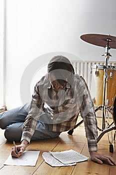 Man BY Drum Kit Writing Music On Floor