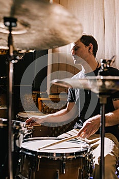 Man drummer playing drums in recording studio