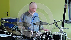 Man Drummer playing his Drum kit with many cymbals while drumsticks are turning in hands