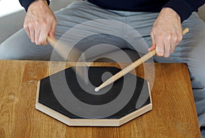 Man drumming on a practice pad at home