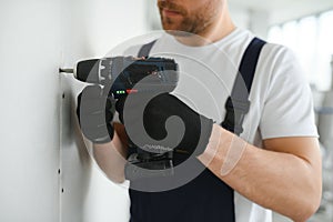 man drywall worker installing plasterboard sheet to wall.