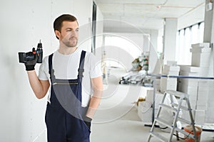 man drywall worker installing plasterboard sheet to wall.