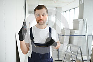 man drywall worker installing plasterboard sheet to wall.