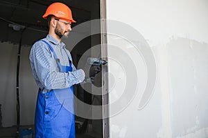 man drywall worker installing plasterboard sheet to wall