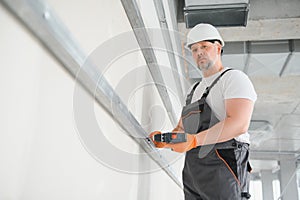 man drywall worker installing plasterboard sheet to wall