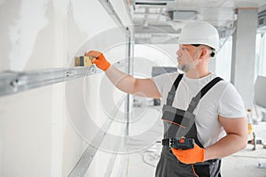 man drywall worker installing plasterboard sheet to wall