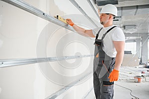 man drywall worker installing plasterboard sheet to wall