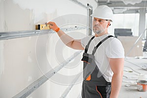 man drywall worker installing plasterboard sheet to wall