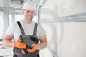 man drywall worker installing plasterboard sheet to wall