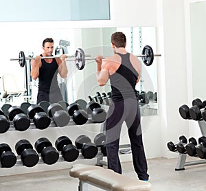 Man with dumbbell weight training equipment gym