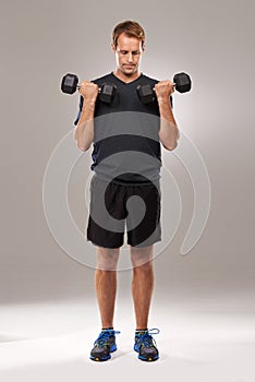 Man, dumbbells and weightlifting fitness in studio or exercise performance, training or grey background. Male person
