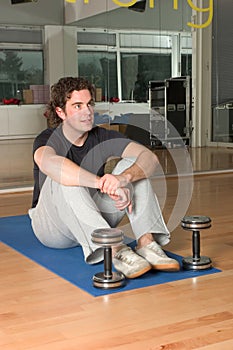 Man with dumbbels on exercise mat
