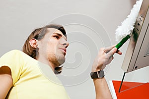 Man dusting his apartment