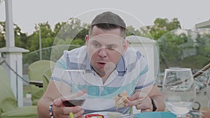 A man eagerly eats junk food in a restaurant.