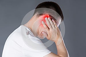 Man with earache, ear pain on gray background photo