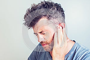 Man with earache is holding his aching ear body pain concept photo