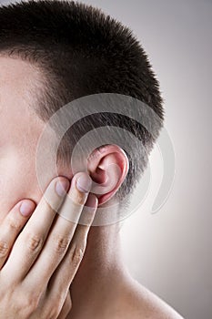Man with a earache. Pain in the human body photo