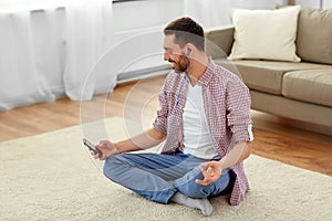 Man in earphones listening to music and meditating