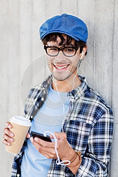 Man with earphones and smartphone drinking coffee