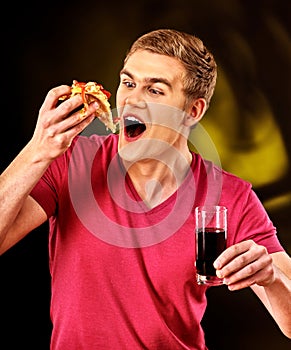 Man eat fast food pizza piece and drink cola glass