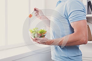 Unrecognizable man has healthy lunch, eating diet vegetable sala