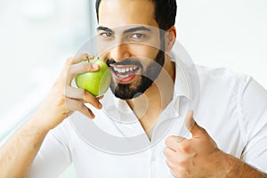 Man Eating Apple. Beautiful Girl With White Teeth Biting Apple.