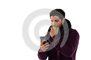 Man eating apple while using mobile phone