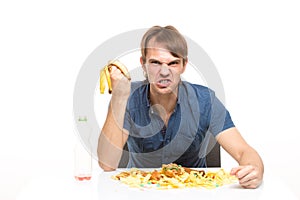 Man eating a banana. on the table a lot of dirt