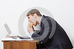 Man eating burger at desk