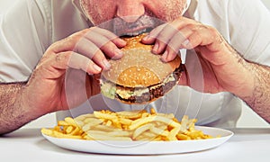 Man eating burger and french fries