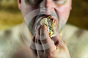 Man eating Burger. Topless man eating burger