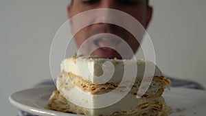 Man eating a cake, closeup, steadycam shot, hungry exited mouth, licking lips