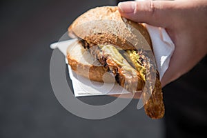 Man eating a couple of grilled Bavarian Bayreuth Bratwurst pork sausage with mustard in wheat bread bun of German food marked