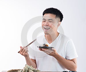 A man is eating delicious zongzirice dumpling and feel delicious on Dragon Boat Festival, Asian traditional food