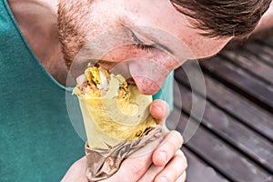 Man is eating doner kebab. concept of gluttony. dependence on food. eating behavior disorder