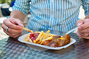 Man eating German Currywurst