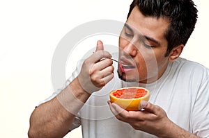 Man eating grapefruit photo