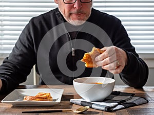 Man eating a grilled cheese sandwich for lunch