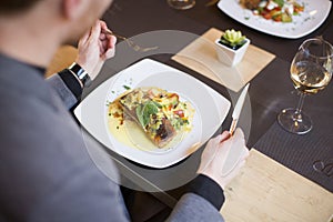 Man eating grilled salmon at restaurant