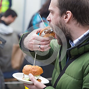 Man eating hamburgers on food festival in Ljubljana, Slovenia.