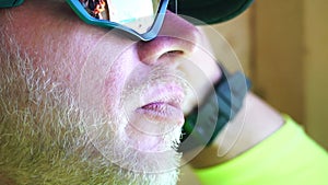 Man eating ice cream. Close-up portrait of young hipster man in sunglases eating ice cream in summer hot weather on the