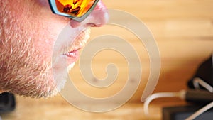 Man eating ice cream. Outdoor closeup portrait of young hipster man in sunglases eating ice cream in summer hot weather
