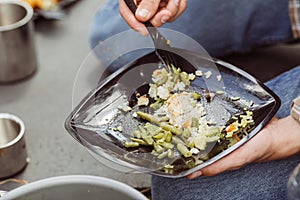 Man eating meat with rice and vegetables in the forest in sunny